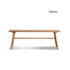 Acuto natural solid cherry dining bench with braced legs, shown beside a dining table as a warm timber bench seat for compact dining spaces