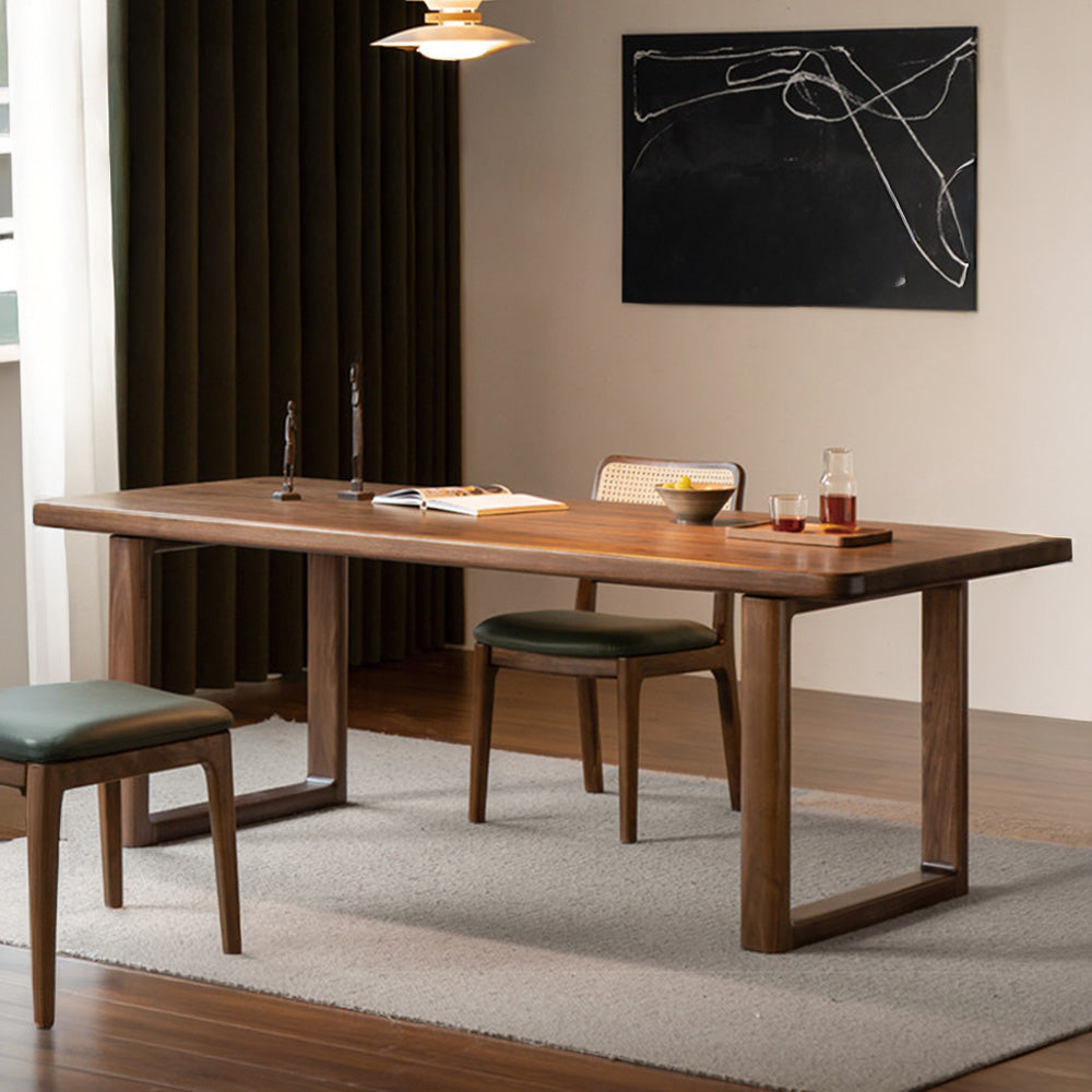 Ancona solid walnut dining table with rectangular legs and rounded corners in a modern dining room.