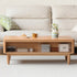 Anzio natural solid oak lift-top coffee table with hidden storage compartment and glass sliding door shelf in a modern living room