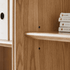 Solid ash display bookcase with adjustable shelves, natural wood grain, and fluted glass detail