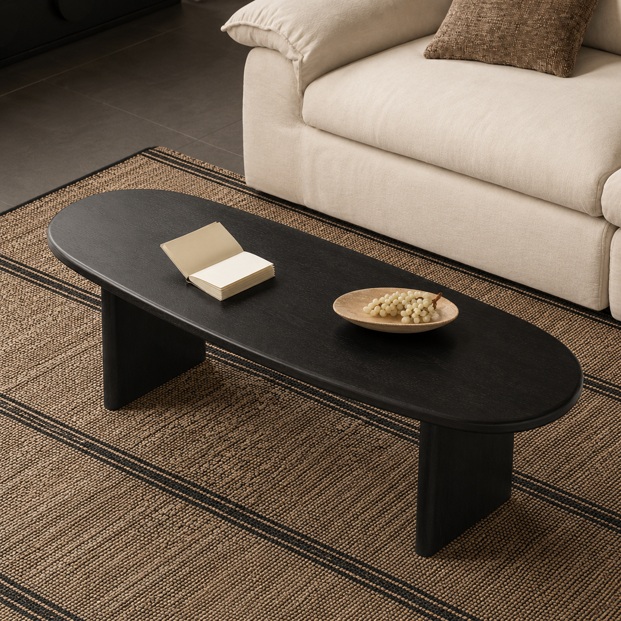 Detailed view of the rounded edge and smooth black wood grain on an oval ash wood coffee table.