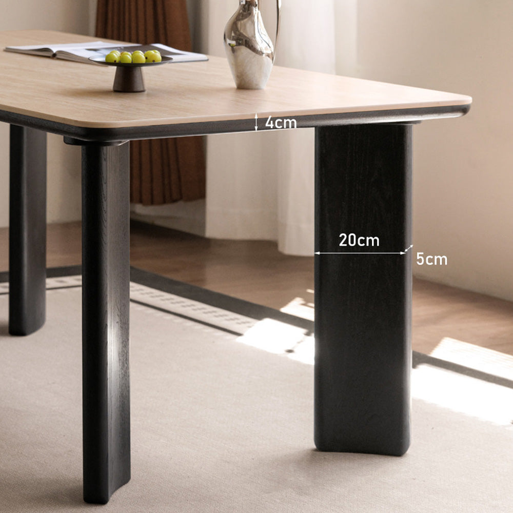 Bremen charcoal solid oak dining table with travertine-look sintered stone top in a modern dining room.
