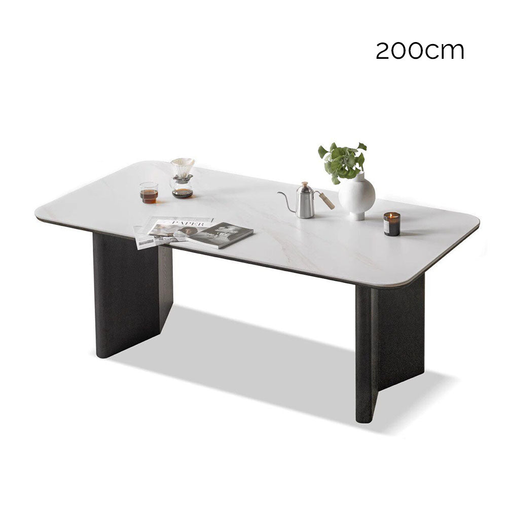 Charcoal solid oak dining table with white marble-look ceramic top and black pedestal legs, styled with dining chairs in a modern dining room.