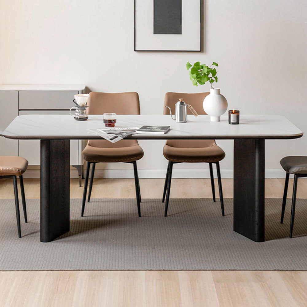 Charcoal solid oak dining table with white marble-look ceramic top and black pedestal legs, styled with dining chairs in a modern dining room.