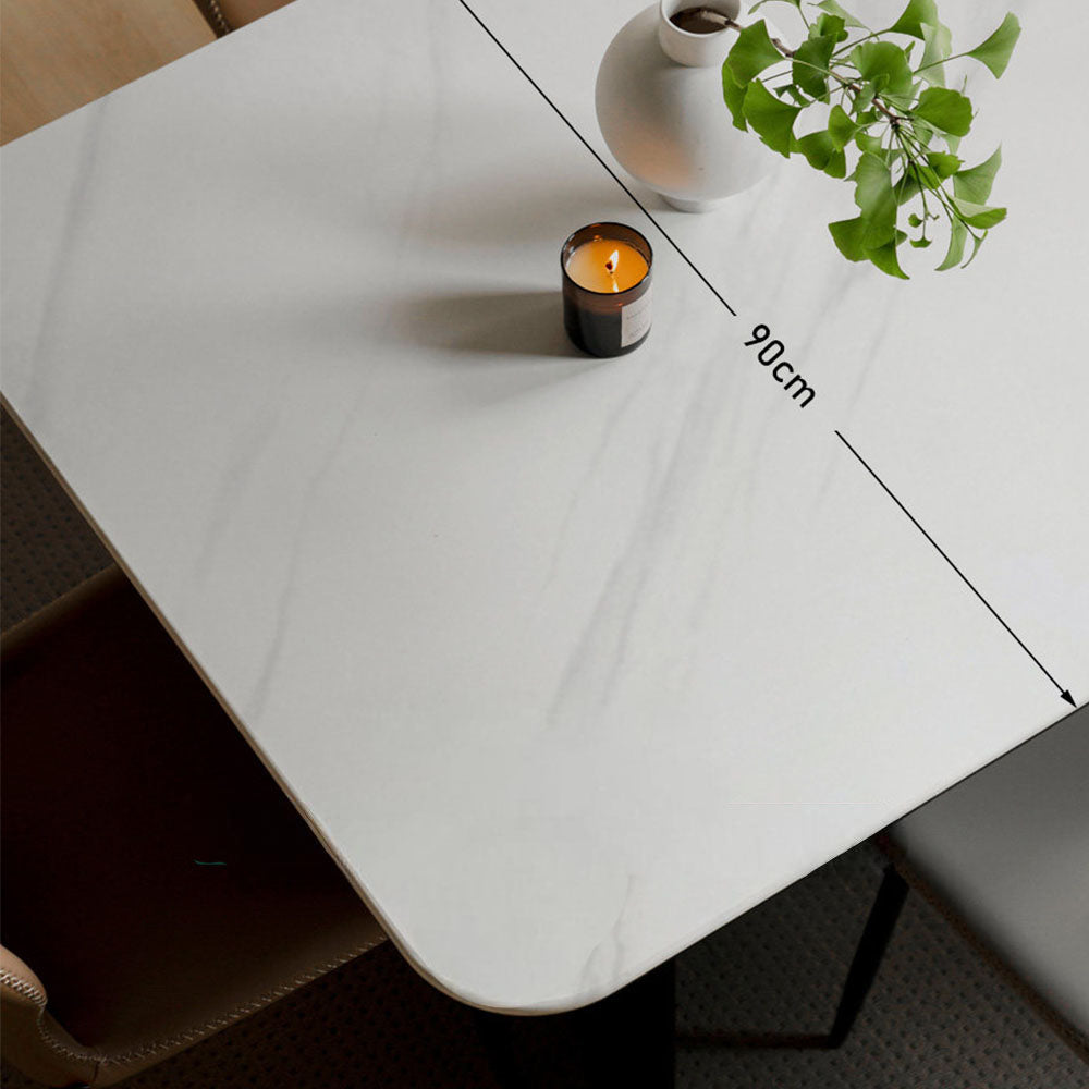 Charcoal solid oak dining table with white marble-look ceramic top and black pedestal legs, styled with dining chairs in a modern dining room.