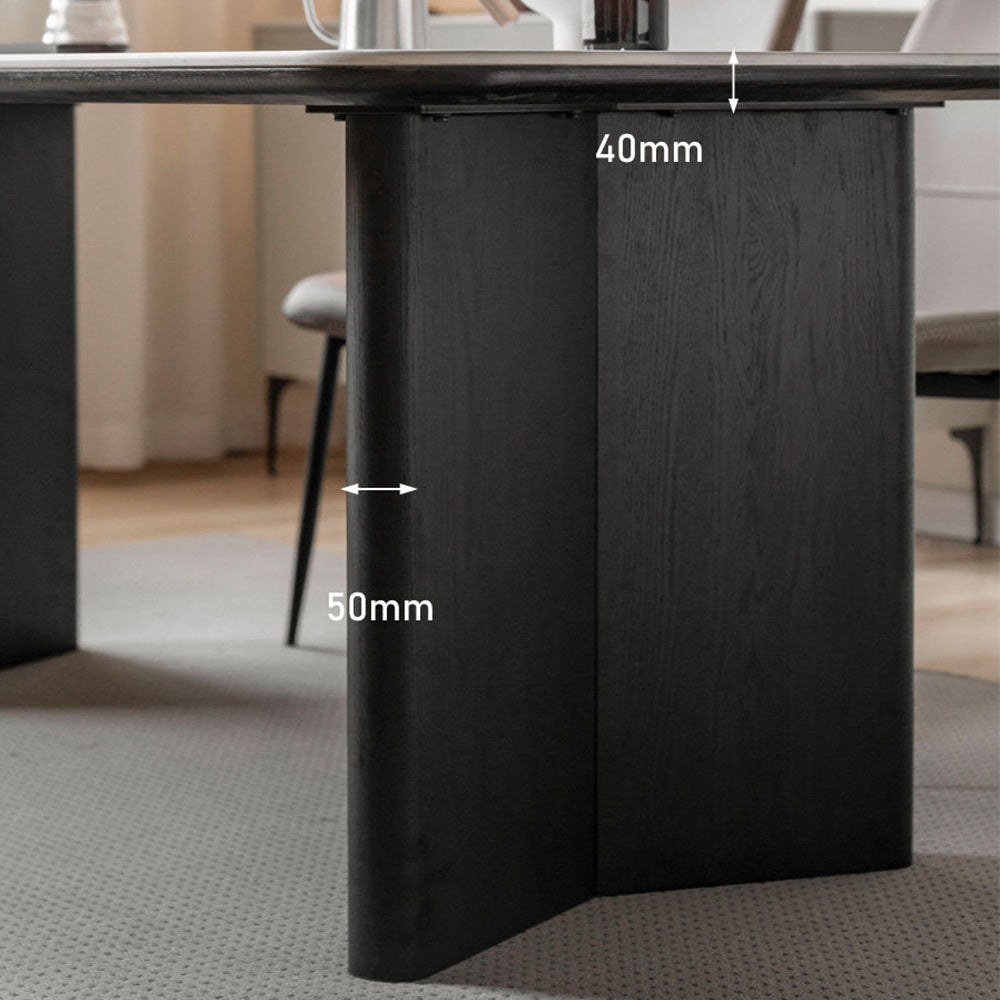 Charcoal solid oak dining table with white marble-look ceramic top and black pedestal legs, styled with dining chairs in a modern dining room.