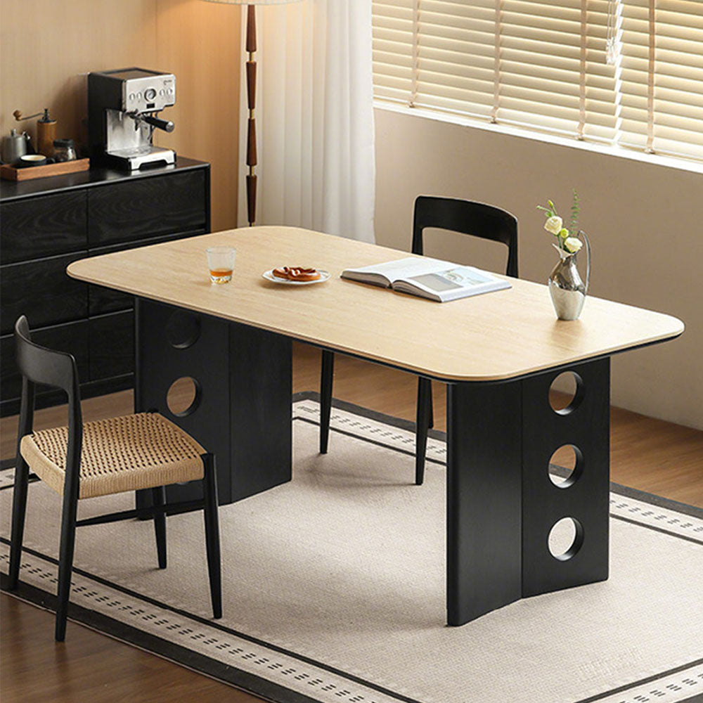 Charcoal solid oak dining table with travertine-look ceramic top and mid-century dot-detail legs, styled with dining chairs in a modern dining room.