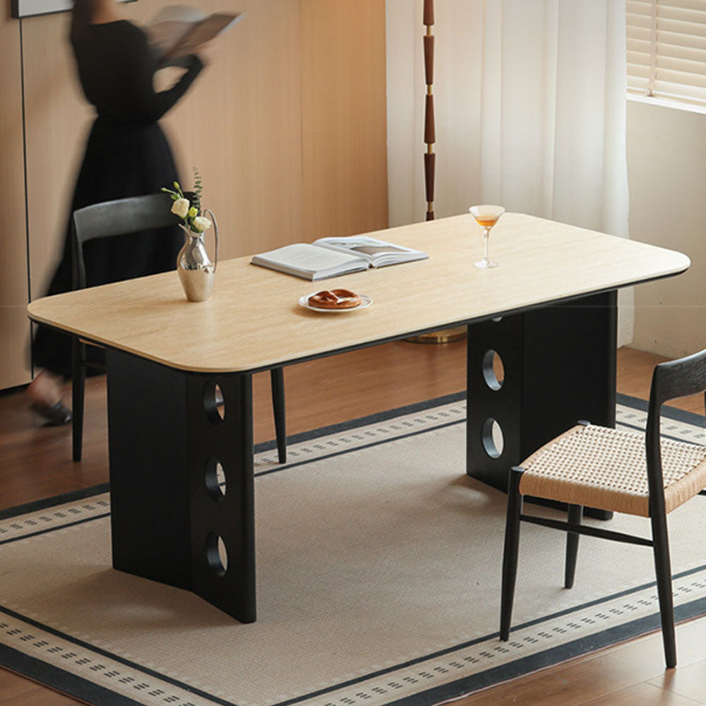Charcoal solid oak dining table with travertine-look ceramic top and mid-century dot-detail legs, styled with dining chairs in a modern dining room.