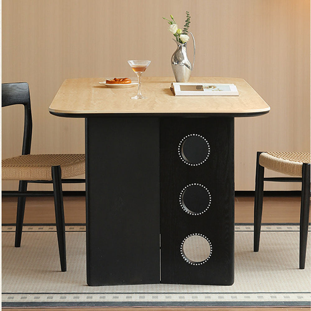 Charcoal solid oak dining table with travertine-look ceramic top and mid-century dot-detail legs, styled with dining chairs in a modern dining room.