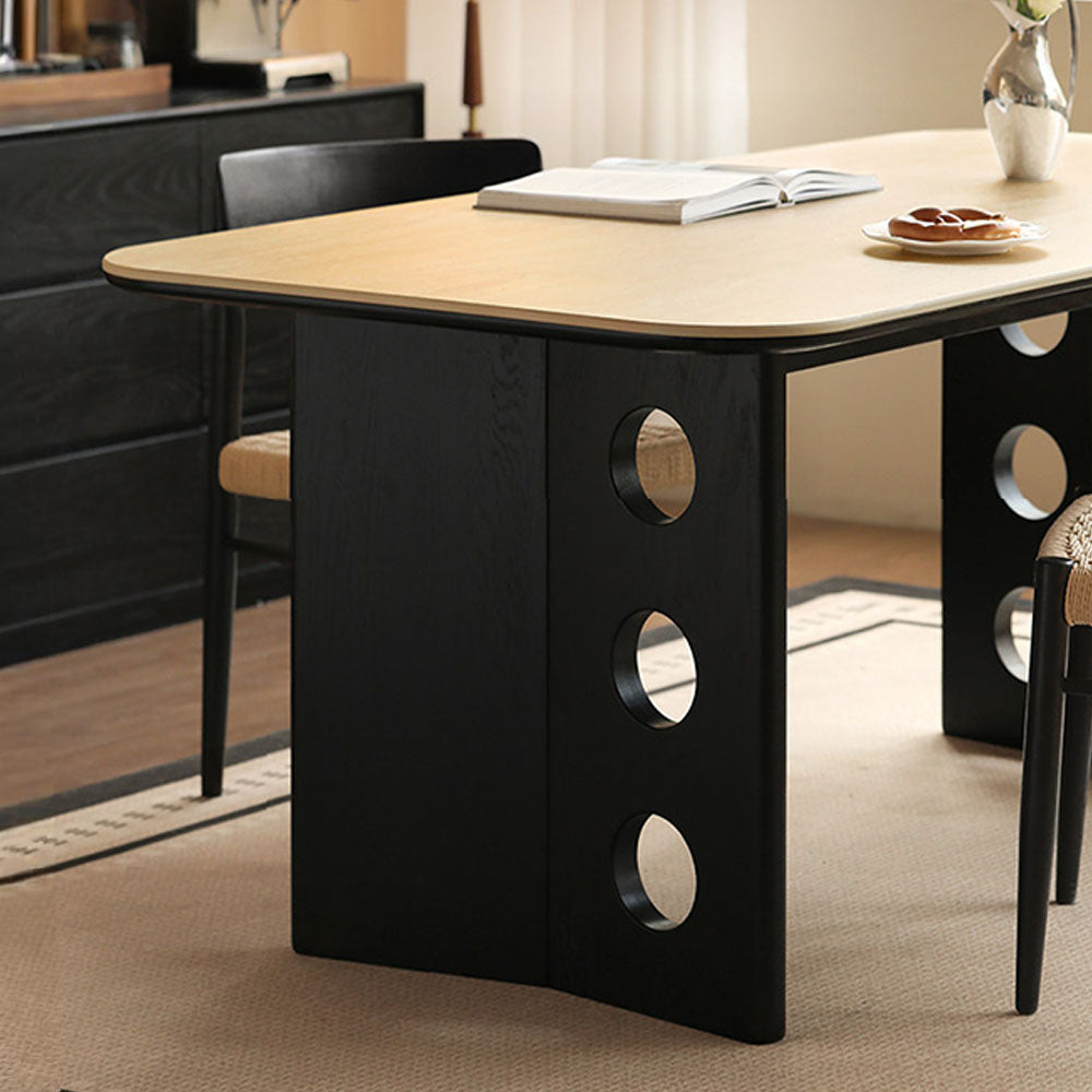 Charcoal solid oak dining table with travertine-look ceramic top and mid-century dot-detail legs, styled with dining chairs in a modern dining room.