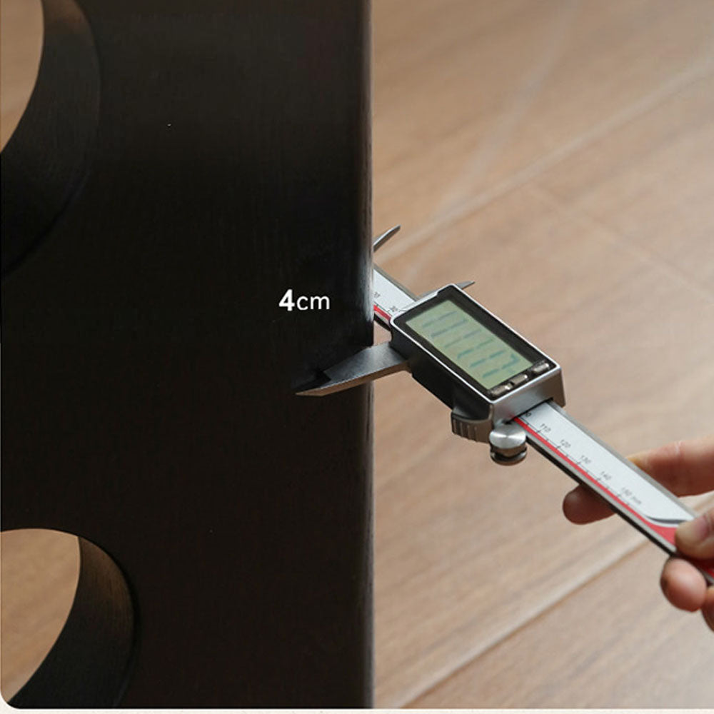 Charcoal solid oak dining table with travertine-look ceramic top and mid-century dot-detail legs, styled with dining chairs in a modern dining room.