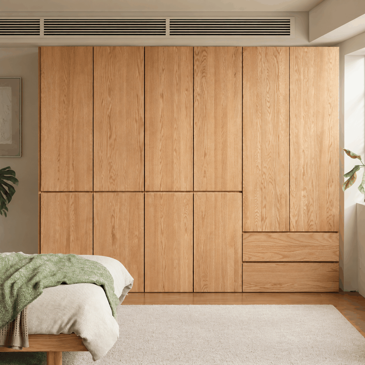 Clovis natural solid oak modular wardrobe closed across bedroom wall
