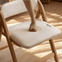 Close-up of the Corese folding chair’s cream cushioned seat showing 36cm seat depth and pressure-resistant padding.