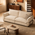 Angled view of a cream striped fabric sofa with deep seat cushions, soft padded arms and exposed wooden side detailing.