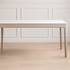 Daejeon Tulip Poplar Painted Dining Table with white rectangular top, rounded corners and slim legs in a minimal room.