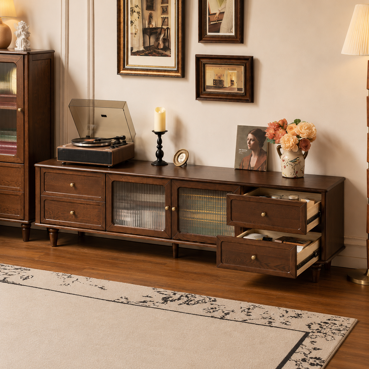Close-up of dark wood TV unit drawers with brass knobs, rounded frame and raised wooden legs.