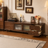 Close-up of dark wood TV unit drawers with brass knobs, rounded frame and raised wooden legs.