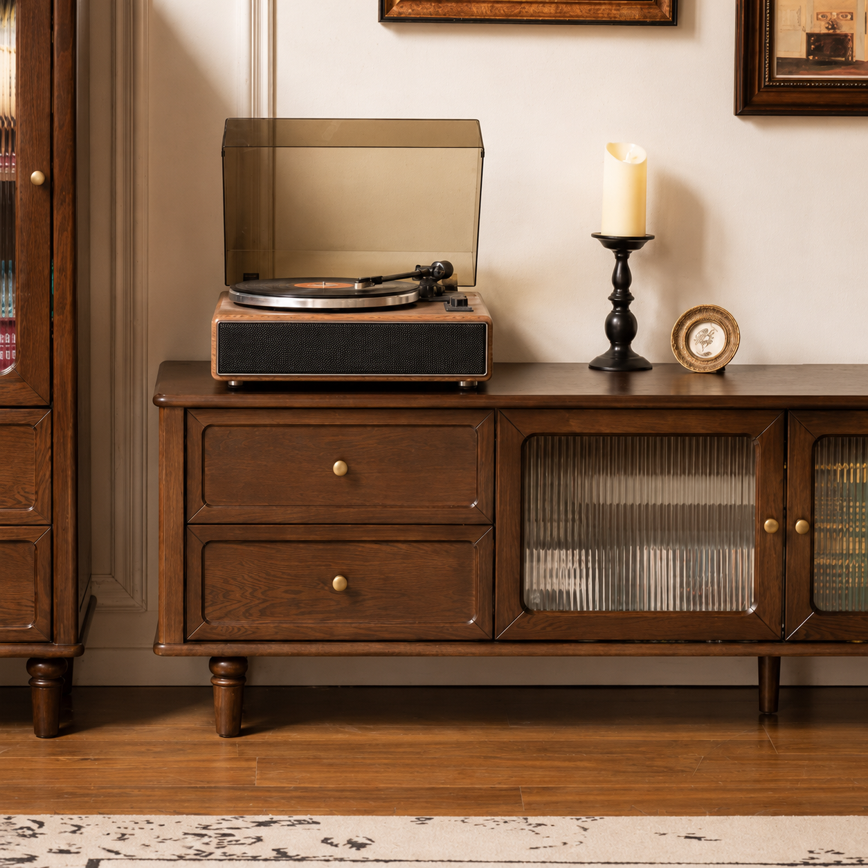 Close-up of a dark wood TV unit featuring drawers, brass hardware and fluted glass cabinet doors.