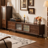 Angled view of a dark wood TV unit with fluted glass doors, storage drawers and brass handles.