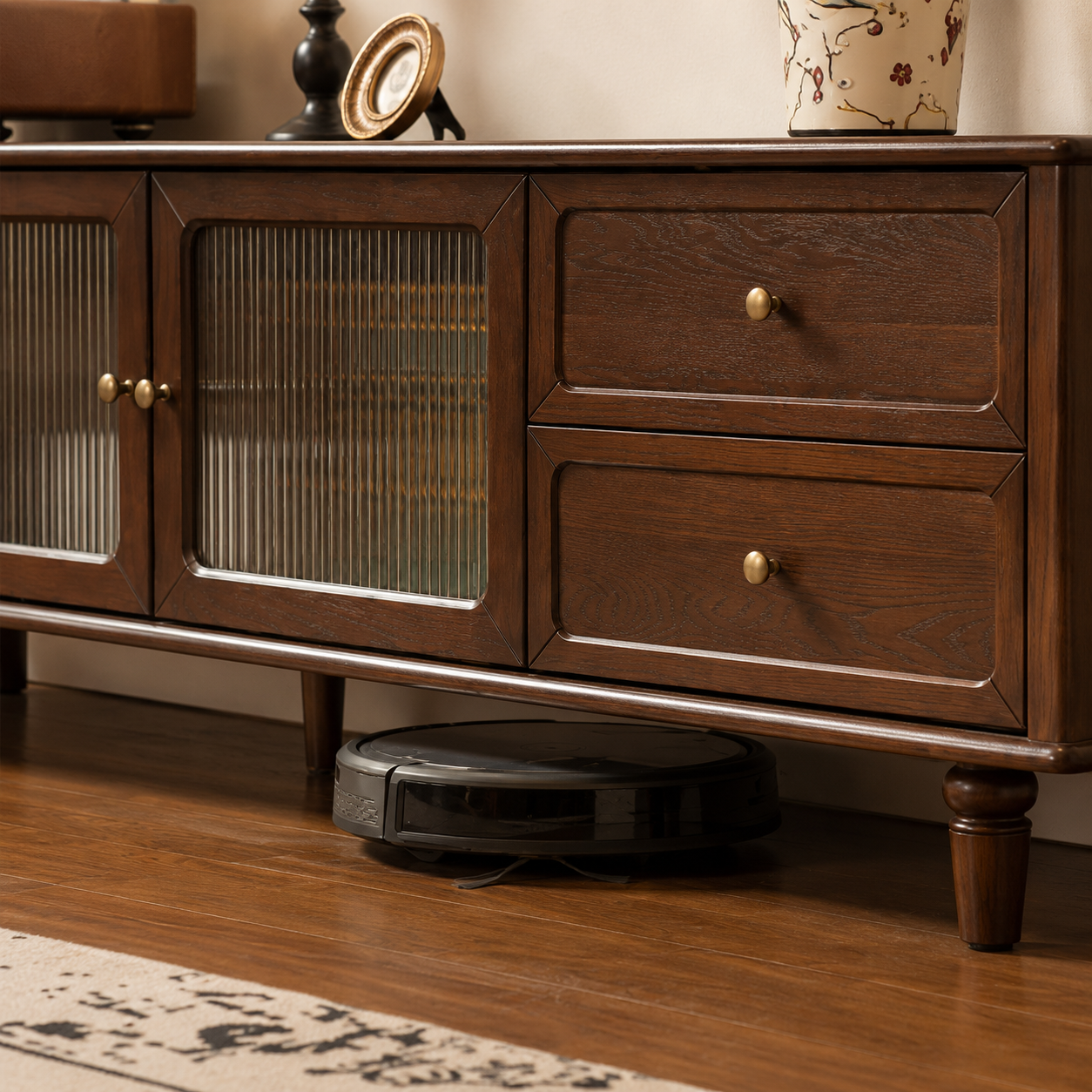 Dark wood TV unit with raised legs providing clearance underneath for a robot vacuum.