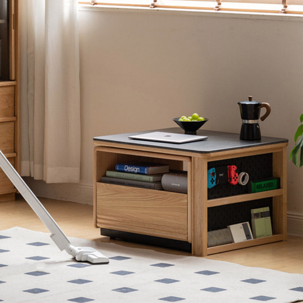 Empoli natural solid ash nesting coffee table set with black ceramic top, storage drawer, pegboard side and removable wheels in a living room