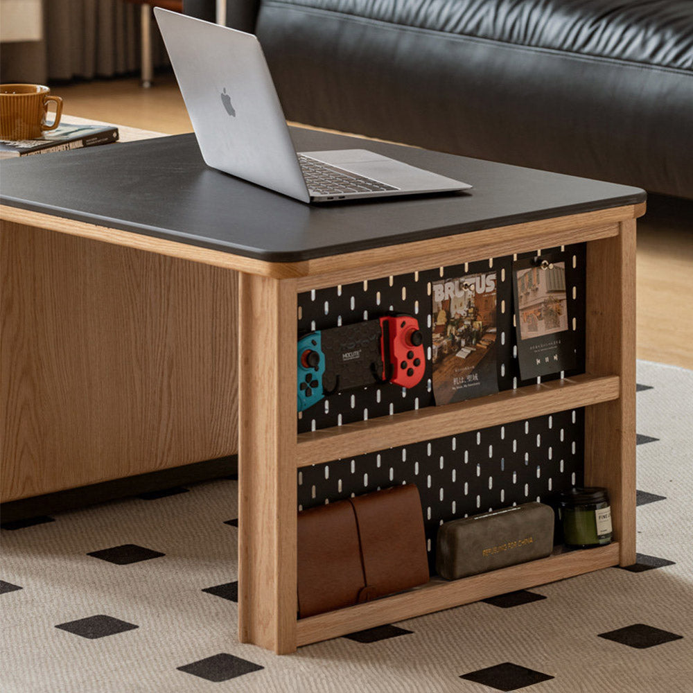 Empoli natural solid ash nesting coffee table set with black ceramic top, storage drawer, pegboard side and removable wheels in a living room