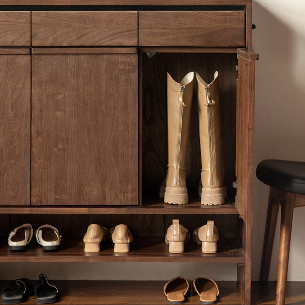 Enna natural solid walnut shoe cabinet with drawers, adjustable internal shoe racks, open shelves and side hooks in an entryway