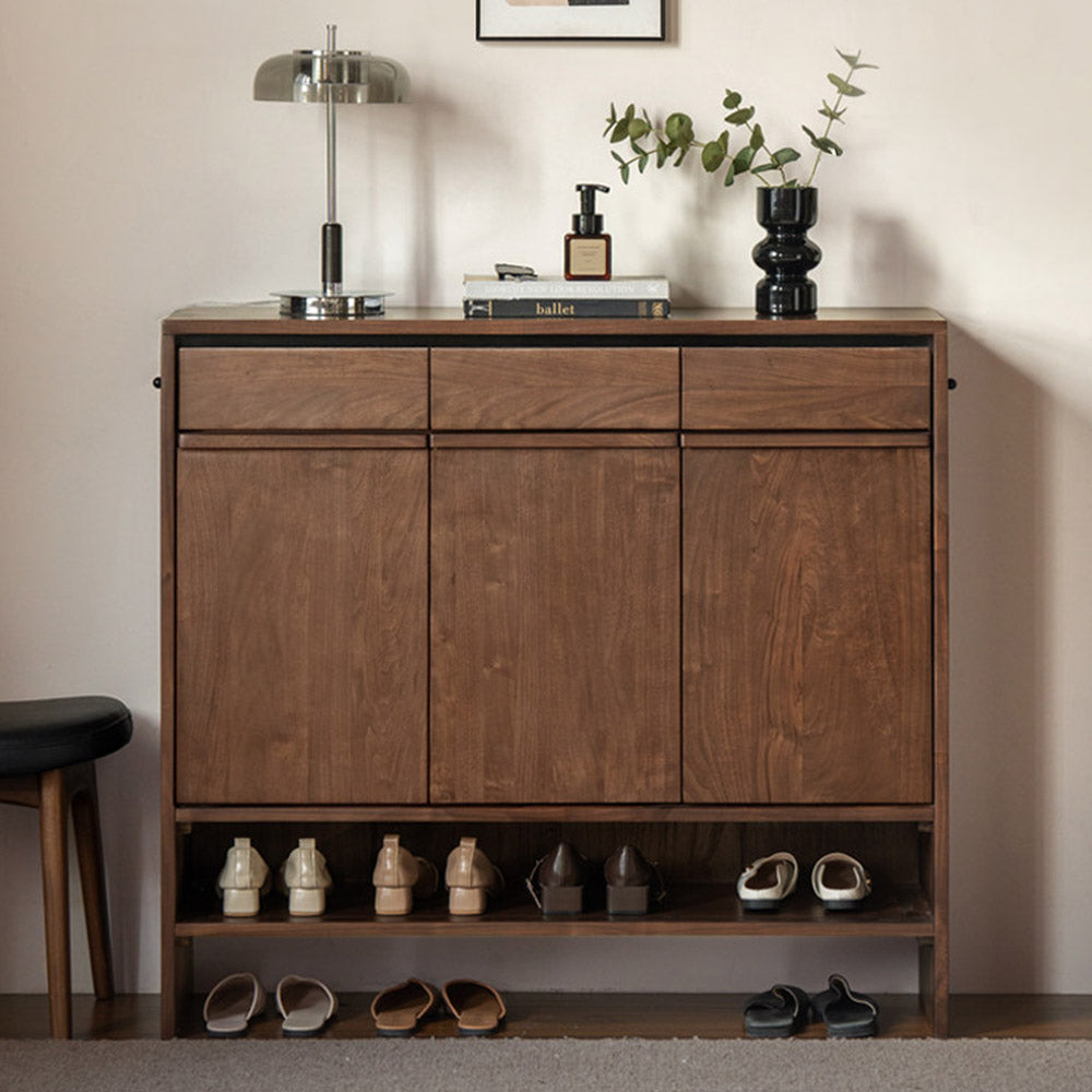 Enna natural solid walnut shoe cabinet with drawers, adjustable internal shoe racks, open shelves and side hooks in an entryway