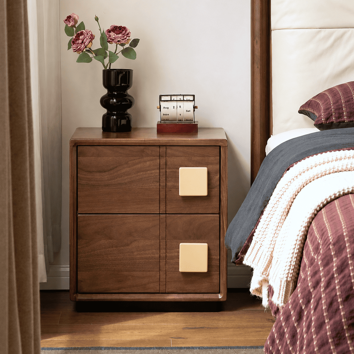 Fontana walnut bedside table with two drawers, cream square handles and floral decor beside bed