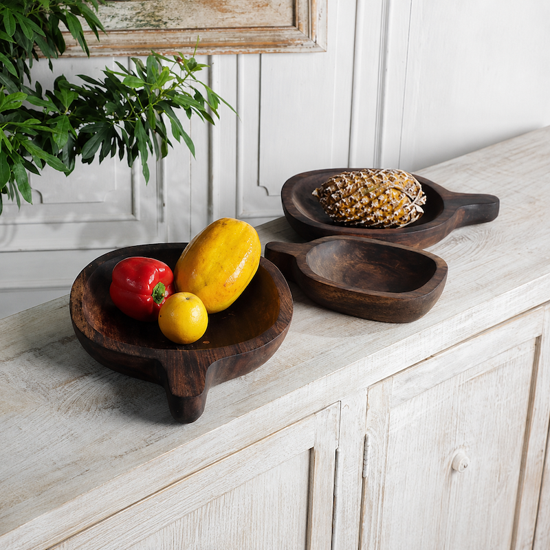 Dark wooden fruit trays in assorted rounded shapes displayed with fresh fruit