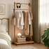 Fukuoka natural solid oak movable coat rack styled in a warm bedroom with clothes, basket and accessories