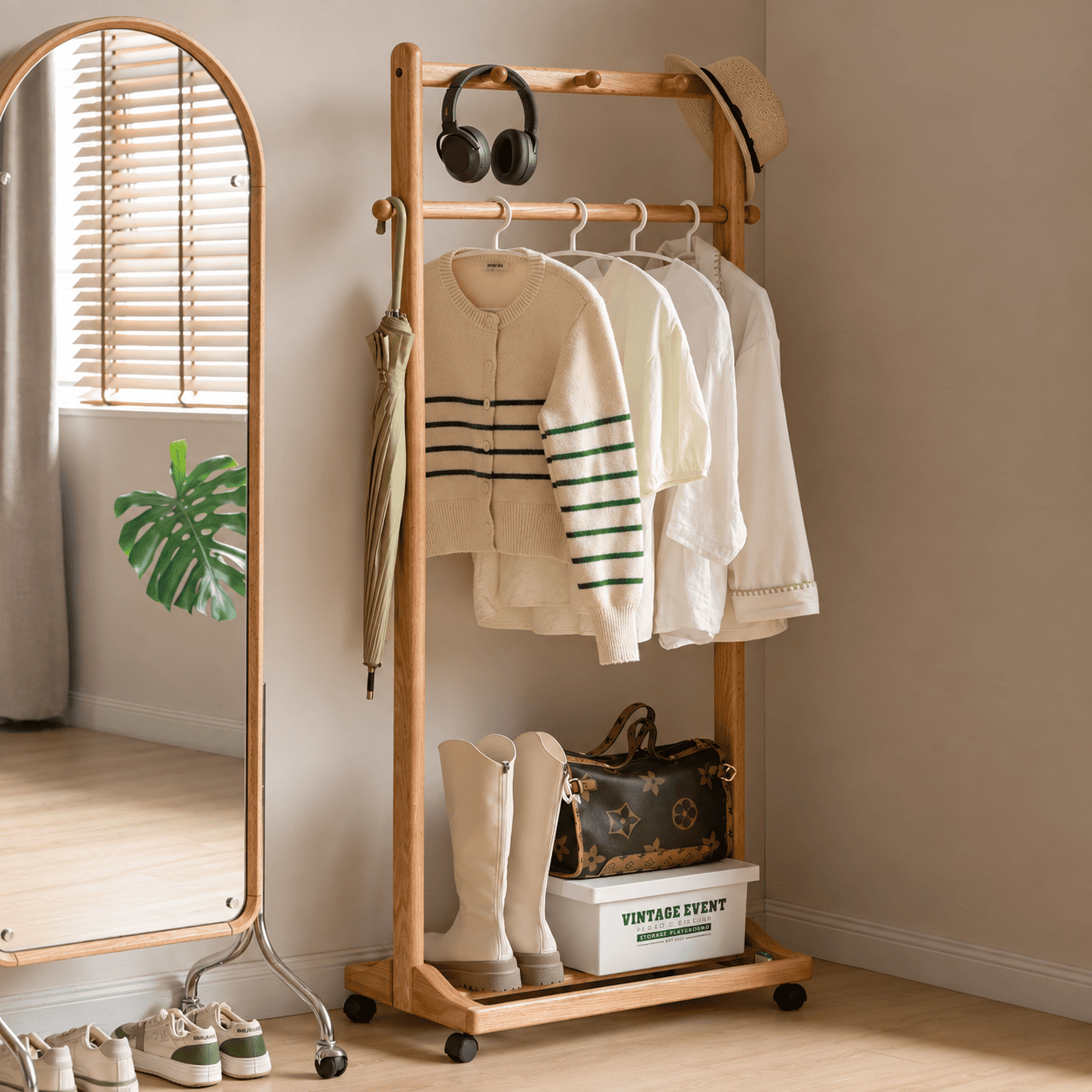 Fukuoka natural solid oak movable coat rack with hanging clothes and accessories beside full length mirror