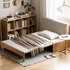 Futtsu Natural Solid Beech Sofa Bed styled with a bookshelf, side table, and throw blanket, showing its natural beech frame, light grey upholstery, and space-saving pull-out bed function.