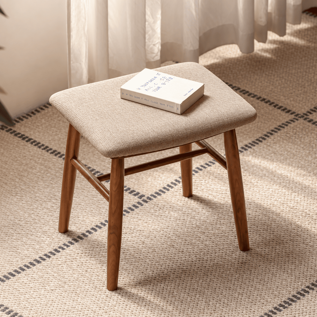 Graz natural solid walnut dressing stool with beige upholstered seat styled on a neutral bedroom rug