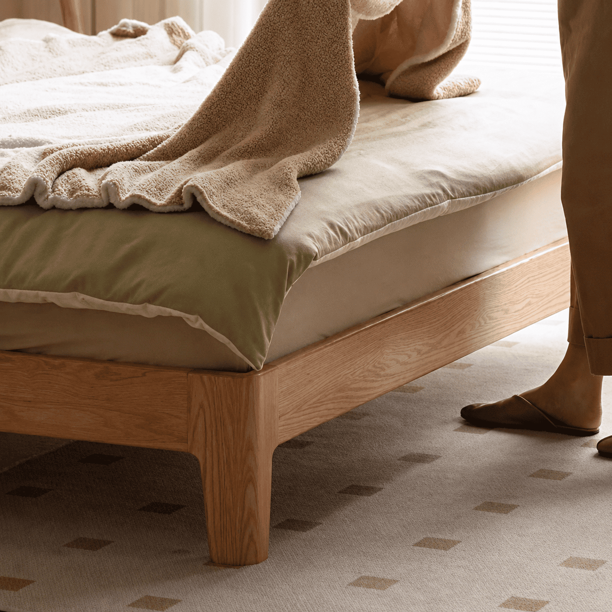Scandinavian-style wooden bed frame with a cream upholstered headboard and natural oak finish
