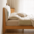 Light oak bed frame with a soft upholstered headboard and contemporary minimalist styling