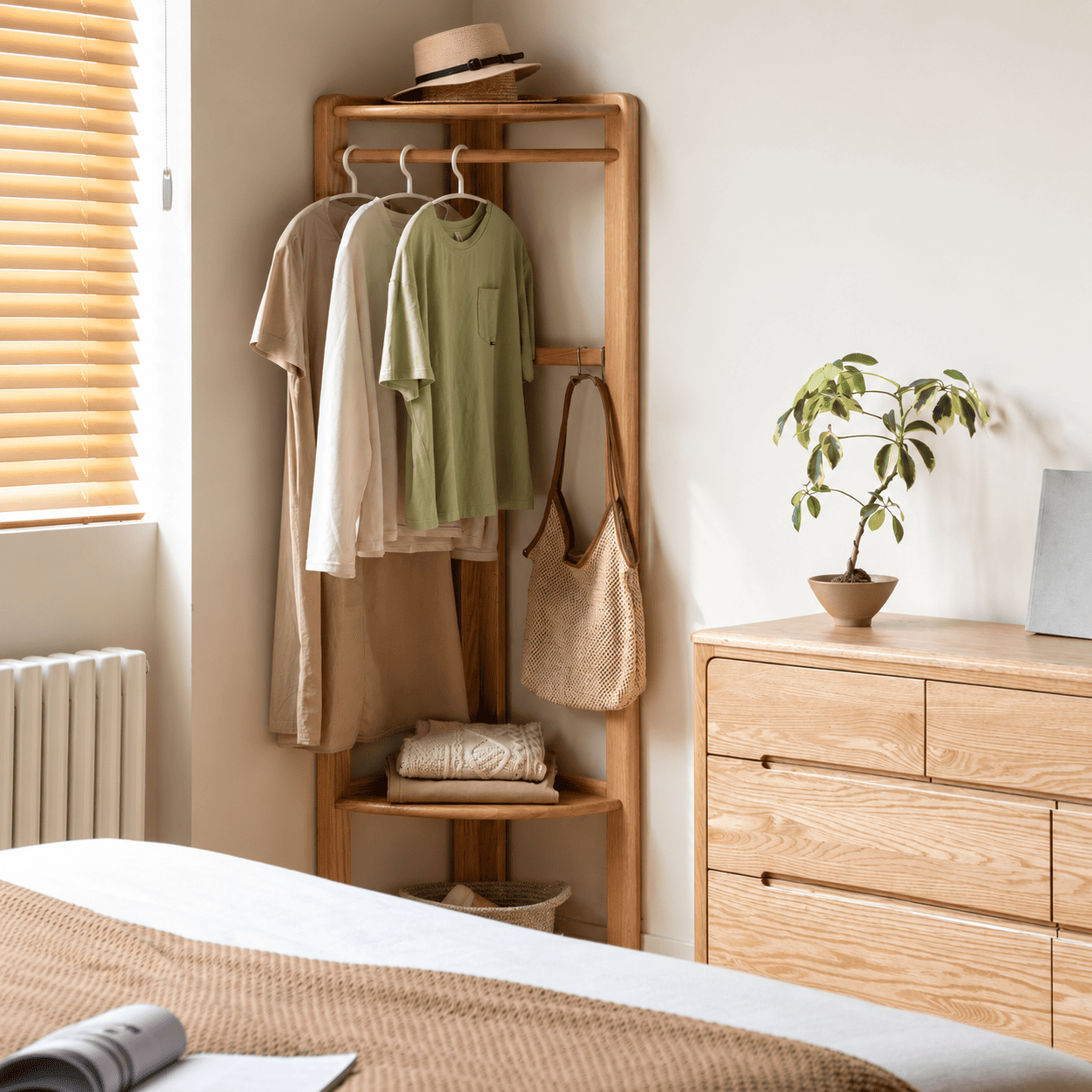 Kent natural solid oak coat rack in bedroom corner with clothes, woven basket and natural oak furniture