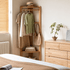 Kent natural solid oak coat rack in bedroom corner with clothes, woven basket and natural oak furniture