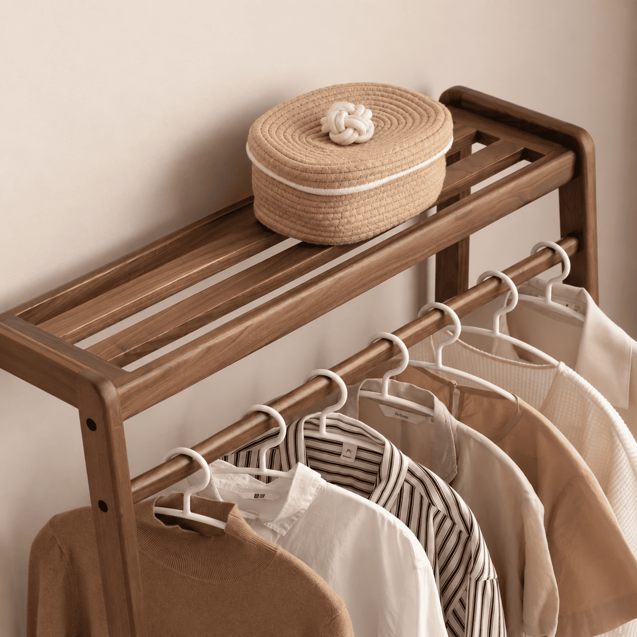Close up of Lahti natural solid walnut coat rack top shelf and hanging rail with storage basket