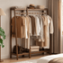 Lahti natural solid walnut coat rack with double hanging rails and lower shelf in a warm bedroom setting