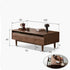 Modena natural solid walnut coffee table with glass-accented drawers and elevated legs in a modern living room setting