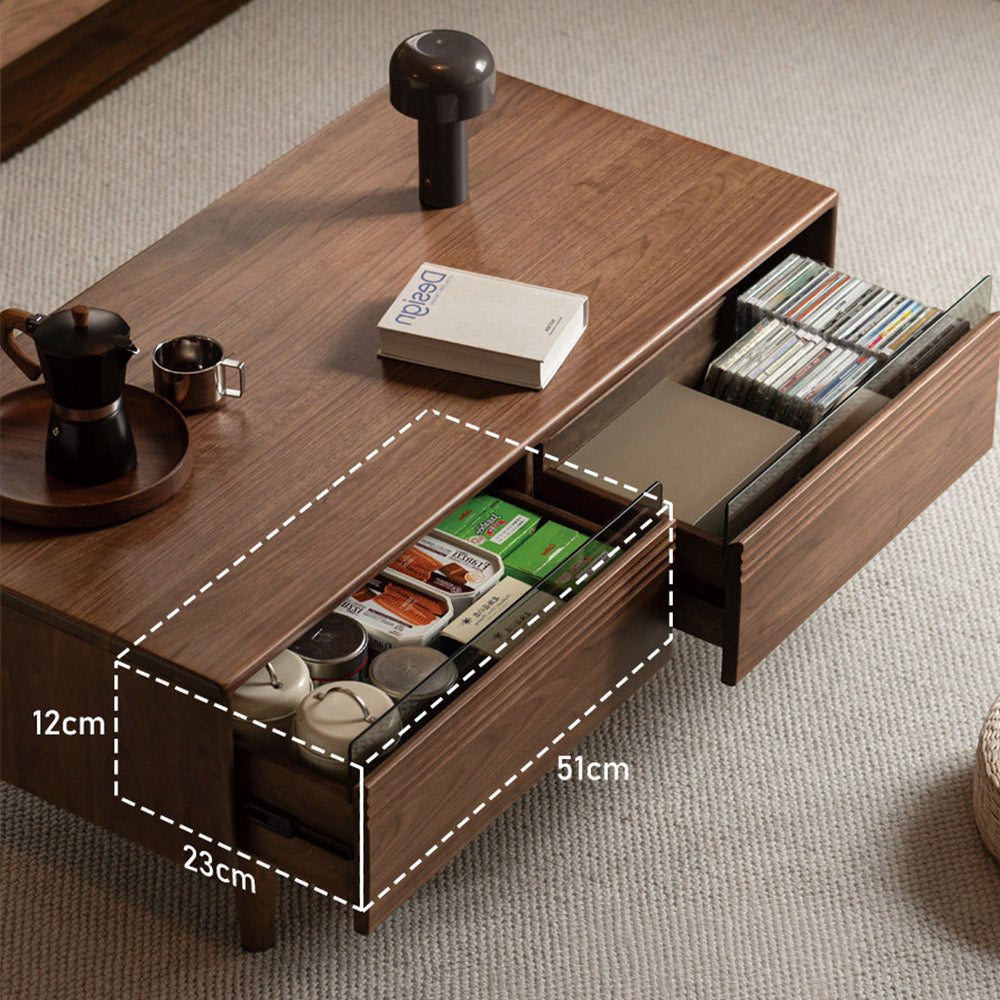 Modena natural solid walnut coffee table with glass-accented drawers and elevated legs in a modern living room setting