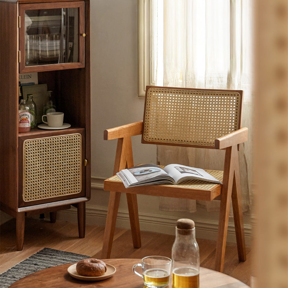 Nordic solid cherry designer chair with woven Indonesian rattan seat and backrest, featuring timber armrests and an angled frame in a sunlit room.