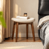 Norman walnut dressing stool with cream cushioned seat styled beside a bed and book