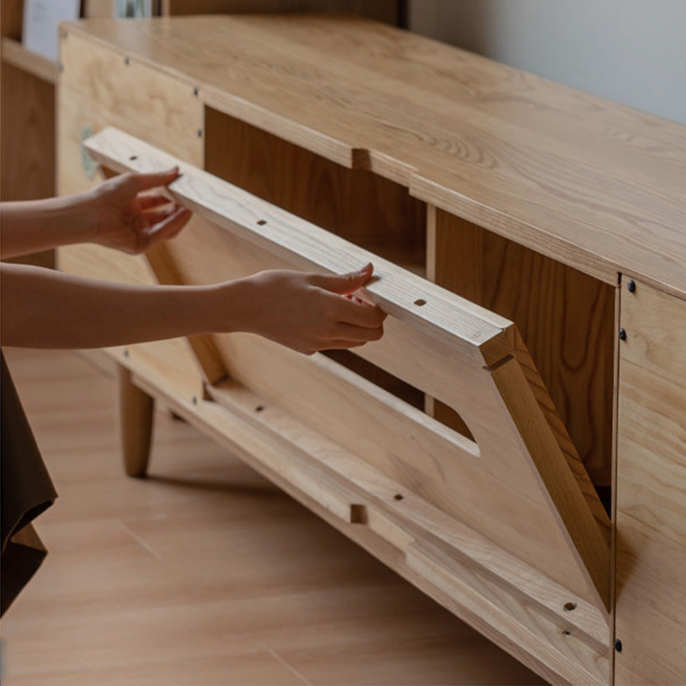 Aurin solid cherry floor standing entertainment unit with built-in LED display, glass sliding-door cabinet, two side drawers and a wide bottom drawer, styled under a wall-mounted TV.