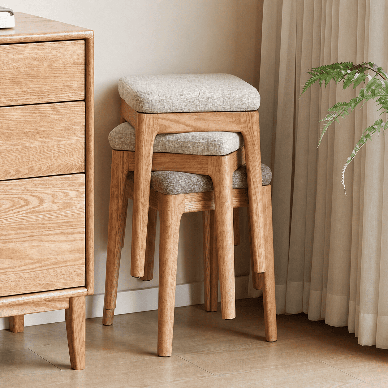 Set of three nesting oak stools with upholstered fabric seats and a space-saving design