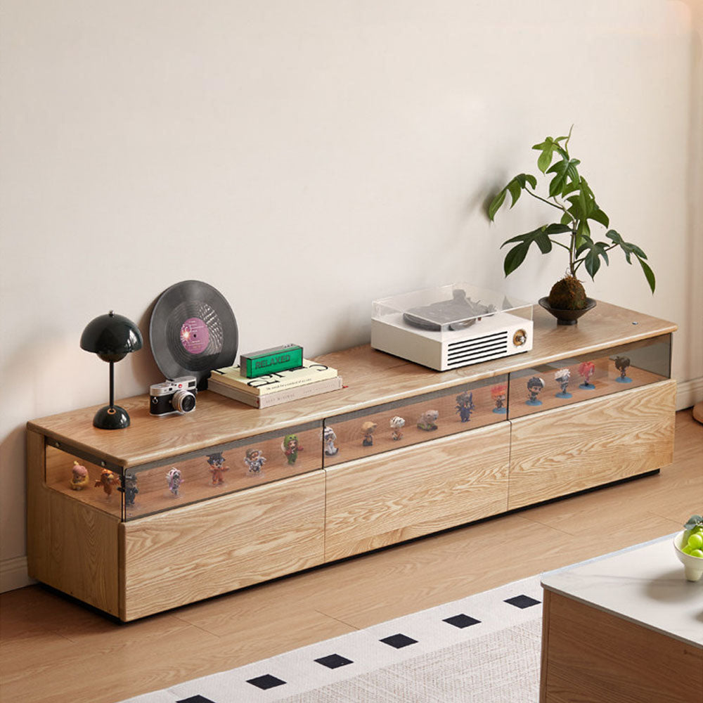 Osini natural solid ash entertainment unit with grey glass display shelf, built-in LED lighting and multiple drawers, styled as a modern floating TV cabinet.