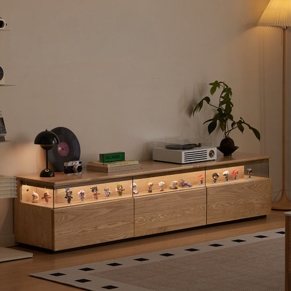 Osini natural solid ash entertainment unit with grey glass display shelf, built-in LED lighting and multiple drawers, styled as a modern floating TV cabinet.