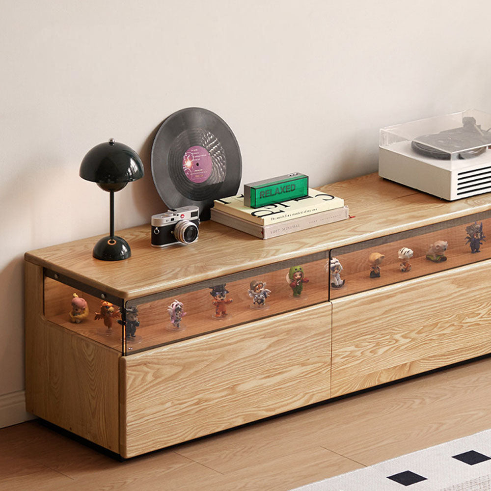 Osini natural solid ash entertainment unit with grey glass display shelf, built-in LED lighting and multiple drawers, styled as a modern floating TV cabinet.