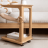 Natural oak mobile side table featuring a spacious top and open shelf for storage